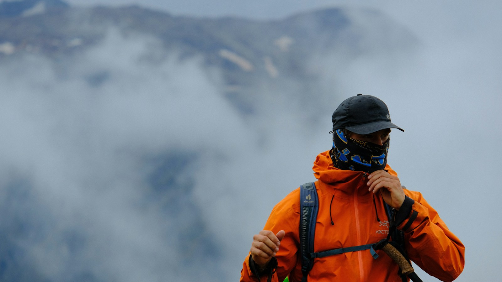 山の休憩で防寒着を羽織る登山者